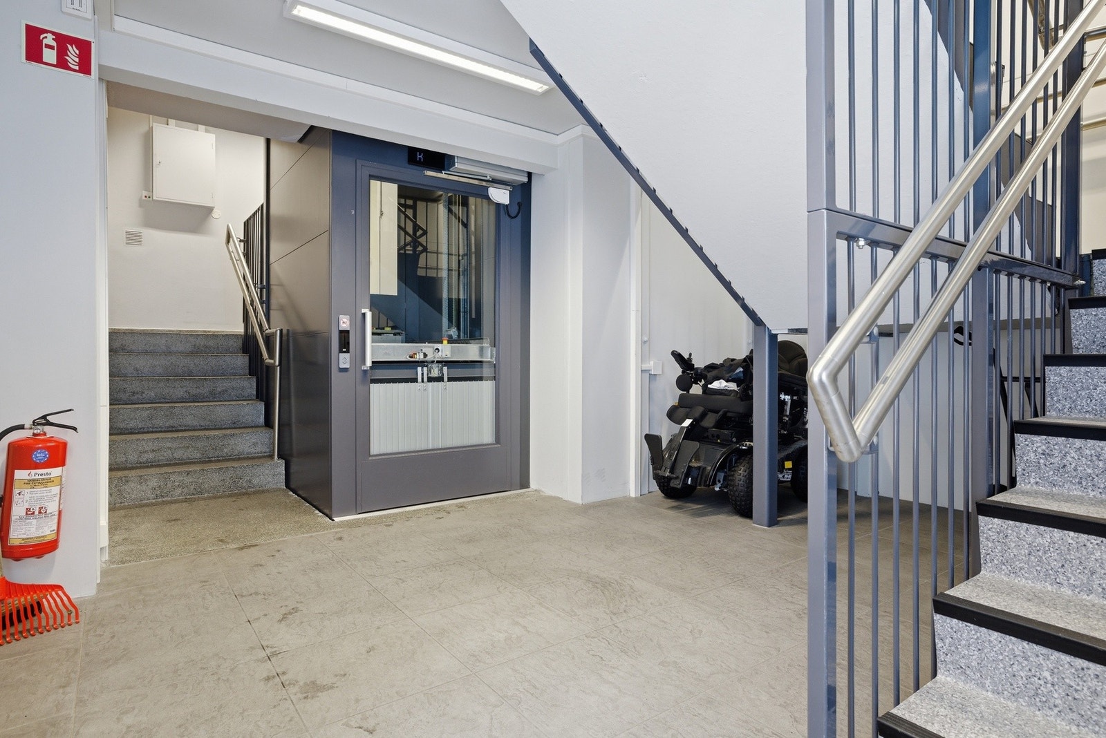 Leilighetens oppgang med trappeløp og heis. Denne leiligheten har adkomst til venstre for heisen. Galleribilde
