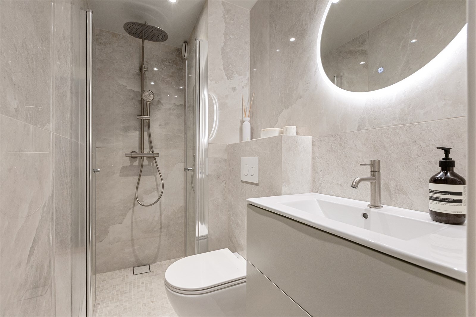 Innredningen er skreddersydd og kompletteres av vegghengt toalett og lysspeil med antidugg. Dusjhjørnet har glassdører og regnfallsdusj Galleribilde