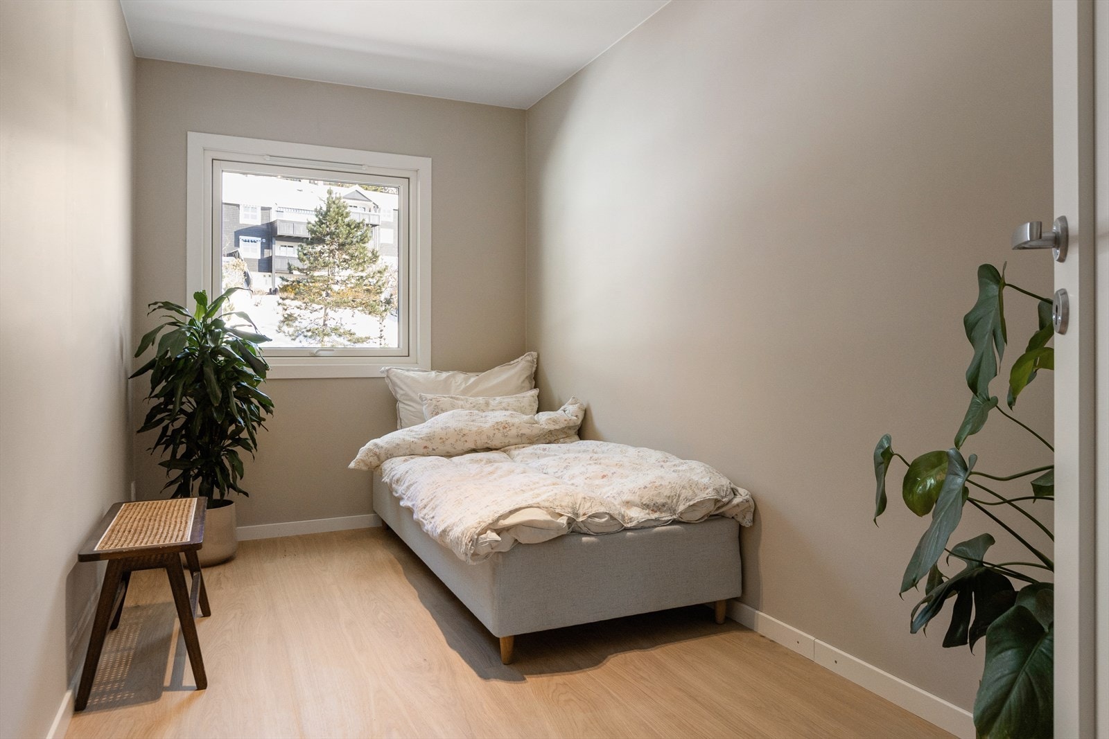 Lyst og fint soverom med 1-stavs parkett og malte veggflater Galleribilde