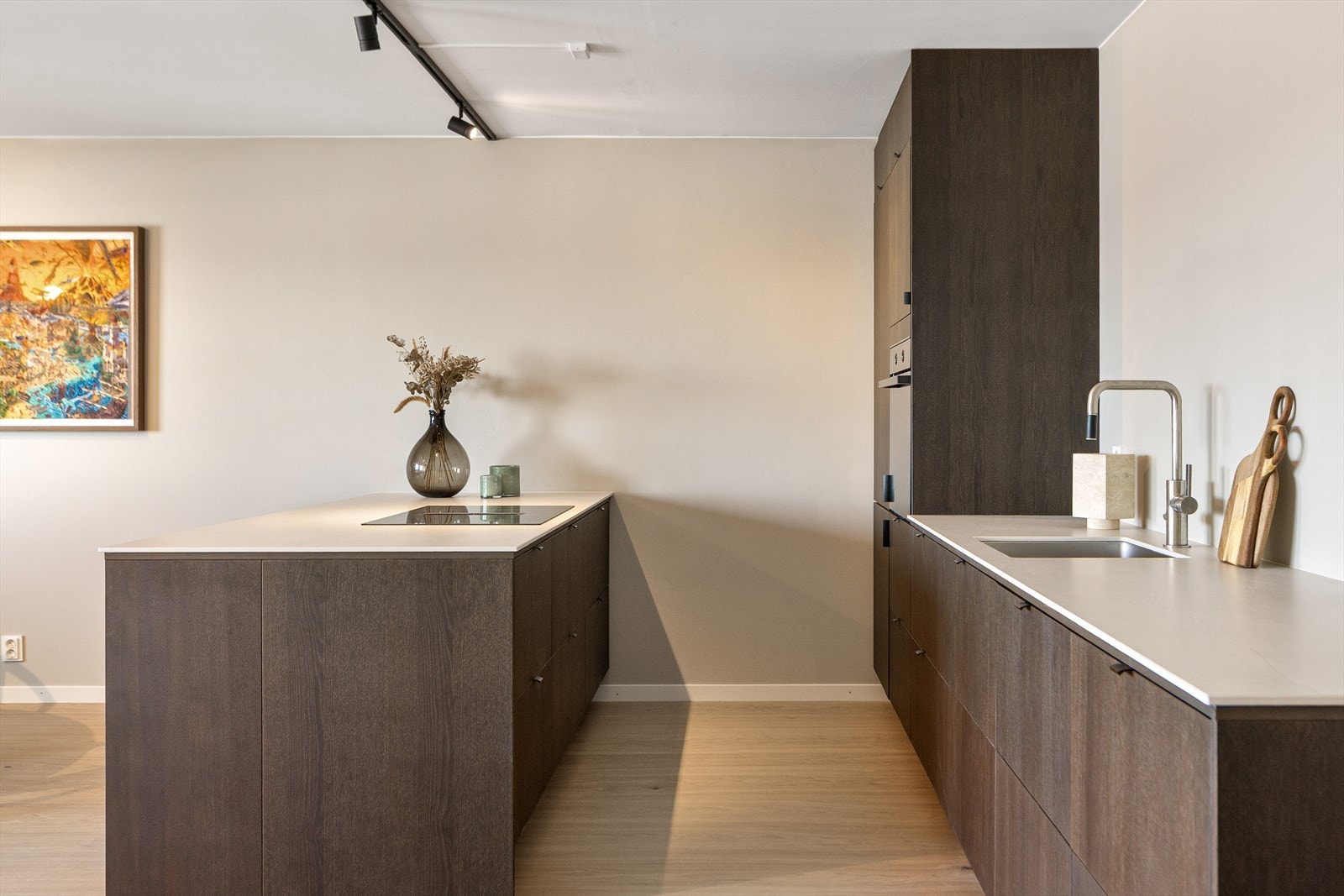 En romslig kjøkkenøy med kokesone gir både ekstra benkeplass og oppbevaring, samtidig som den fungerer som et naturlig samlingspunkt i rommet Galleribilde