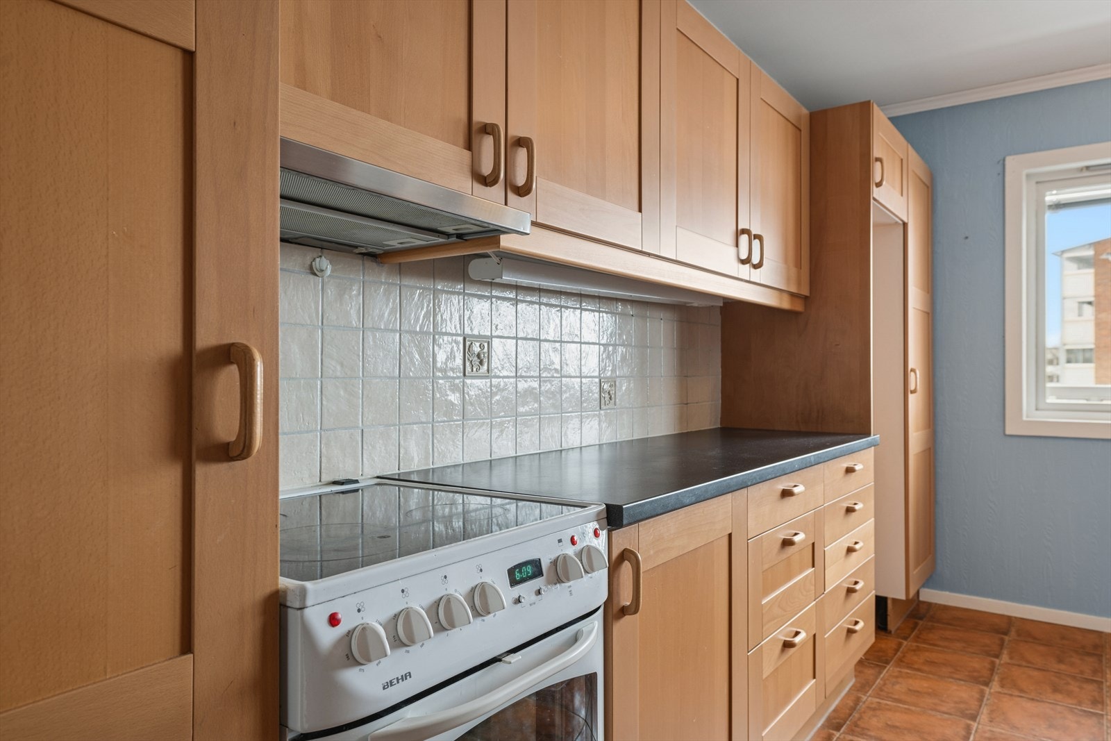 Det er fliser over benken, og rommet er utstyrt med komfyr og opplegg for vaskemaskin Galleribilde