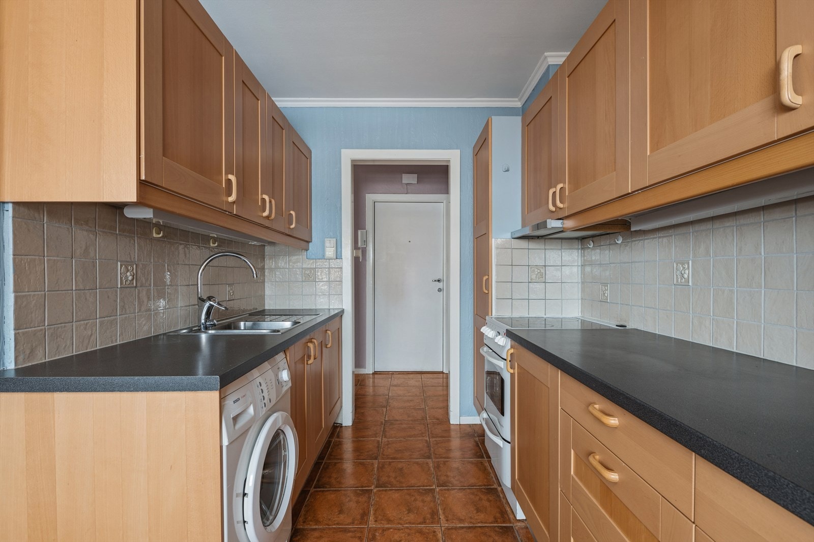 Kjøkkenet er et eget rom med en praktisk innredning med profilerte fronter og laminatbenkeplate. Galleribilde