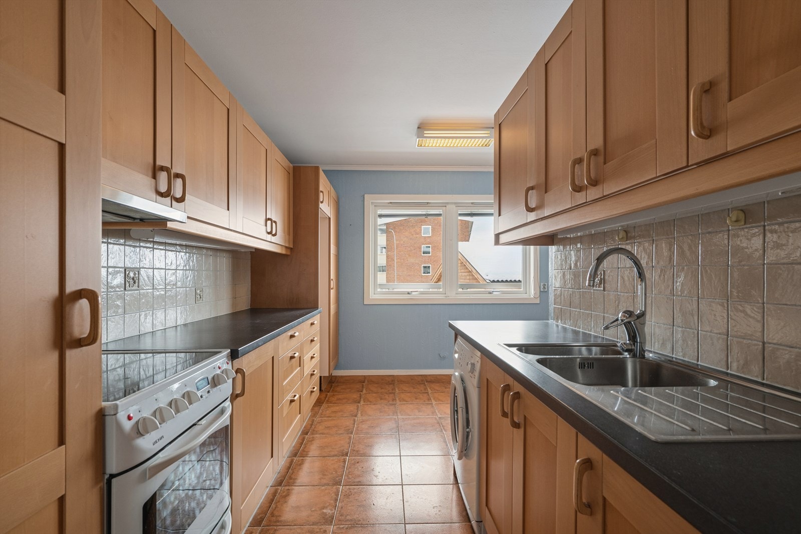 Praktisk kjøkken med rikelig skap- og benkeplass, samt opplegg for vaskemaskin. Galleribilde