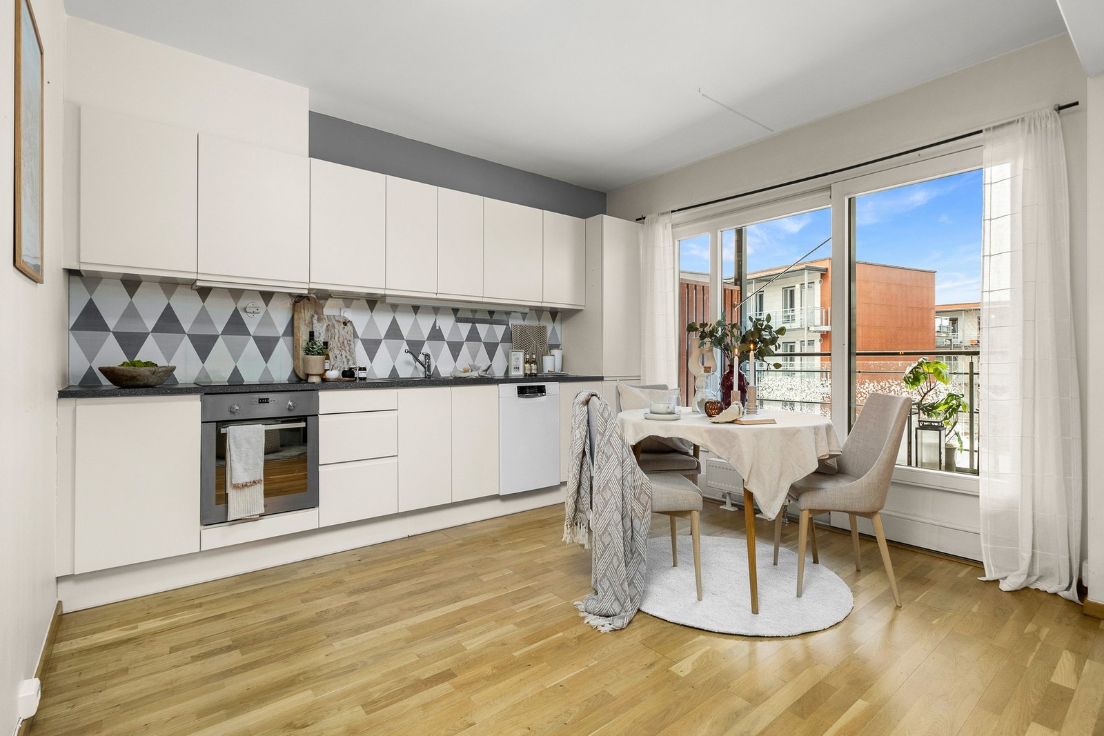 Lyst og tidsriktig kjøkken med integrerte hvitevarer. Galleribilde