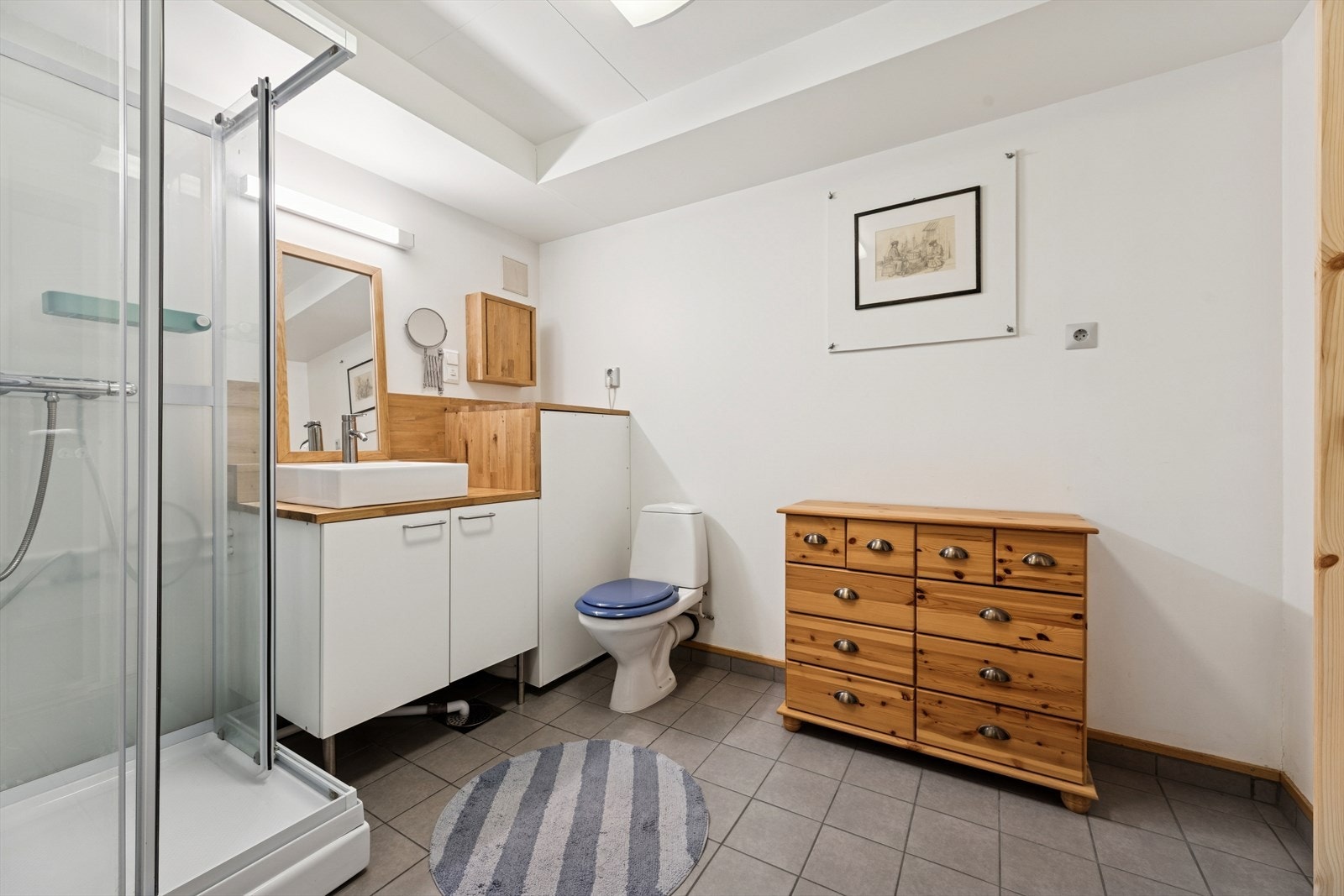 I underetasjen er det et bad med flislagt gulv med varmekabler og glatte vegger. Galleribilde