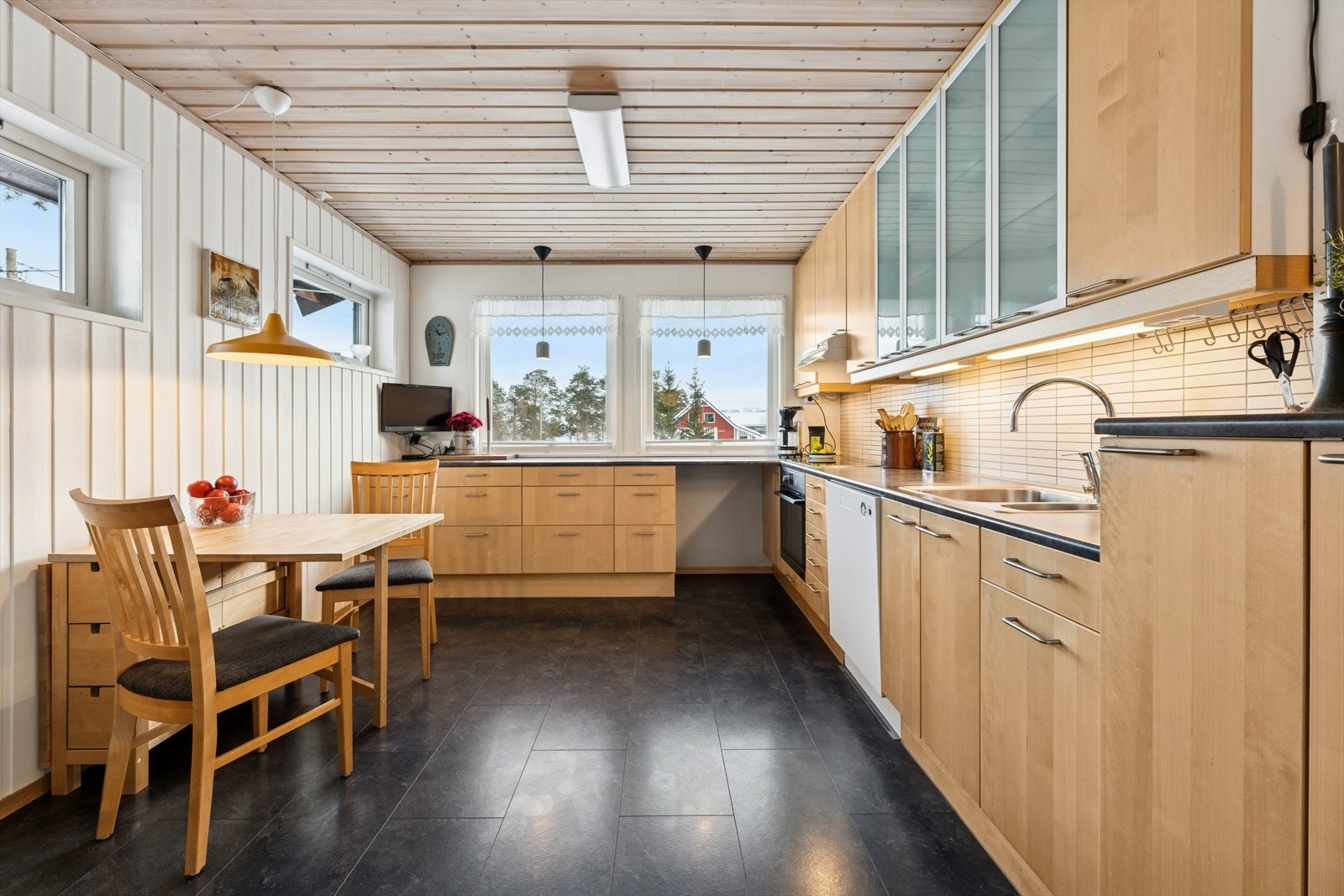 Kjøkkenet har en pen innredning fra 2006 med glatte trefronter og mørk laminert benkeplate med nedfelt kjøkkenkum. Galleribilde