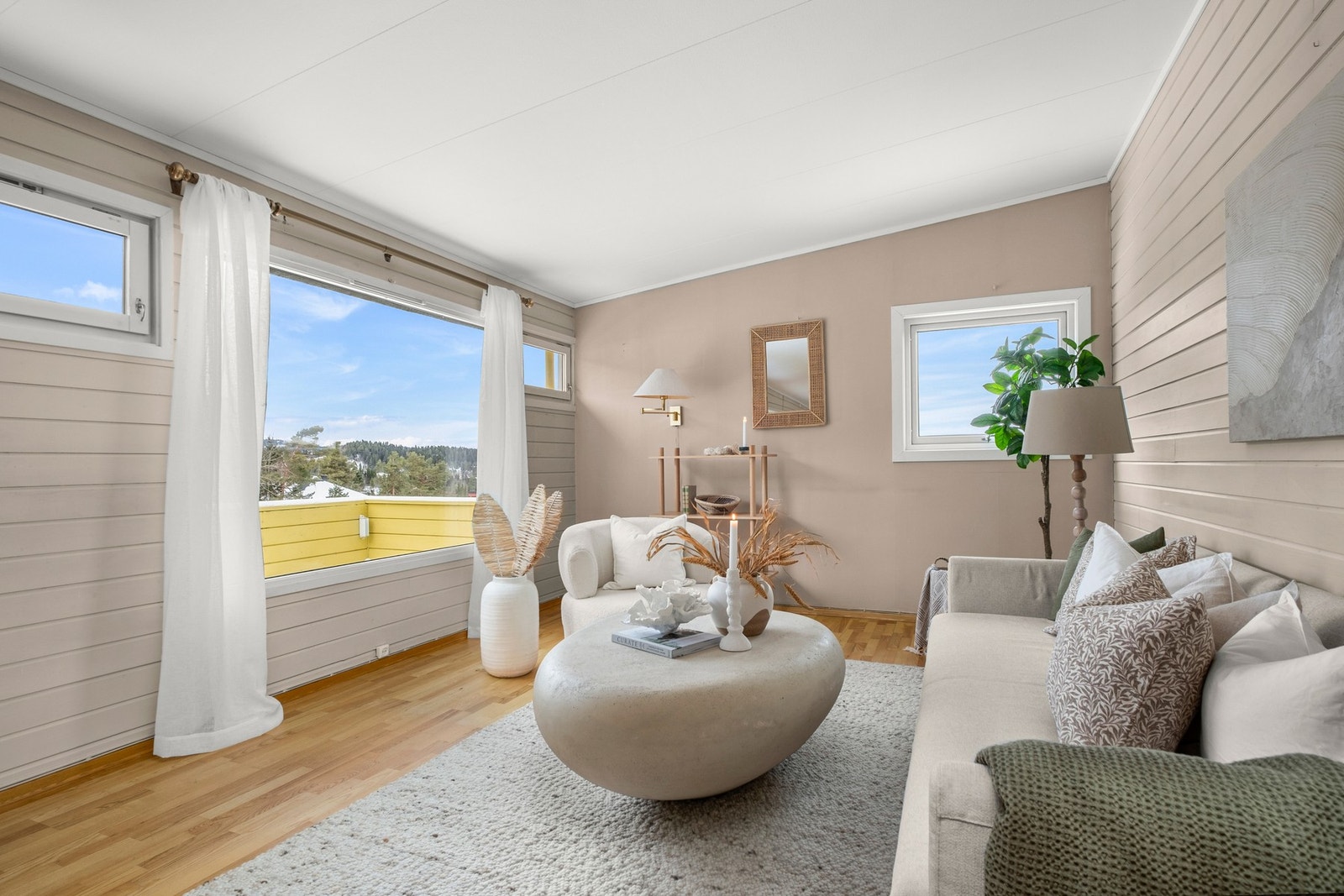 De store vindusflatene bidrar til rikelig med naturlig lys inn i stuen. Galleribilde