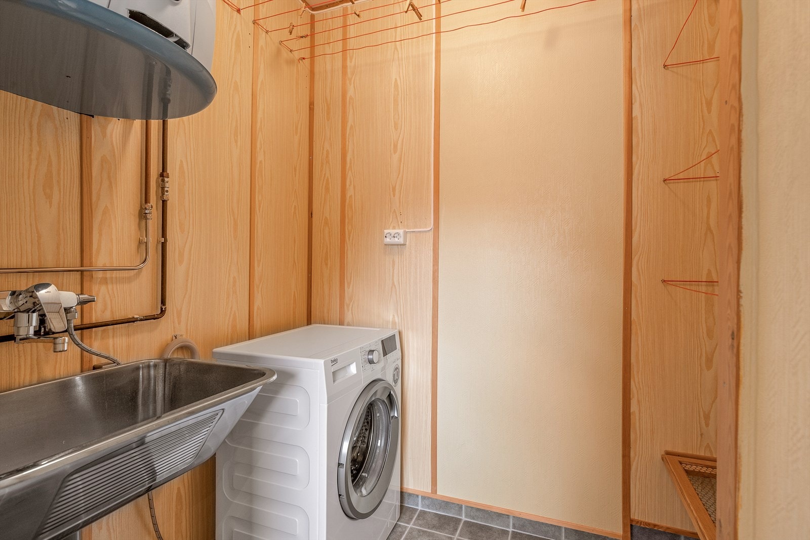 Vaskerom med tilkomst frå kjøkken. Rommet er utstyrt med opplegg for vaskemaskin og utslagsvask. Galleribilde