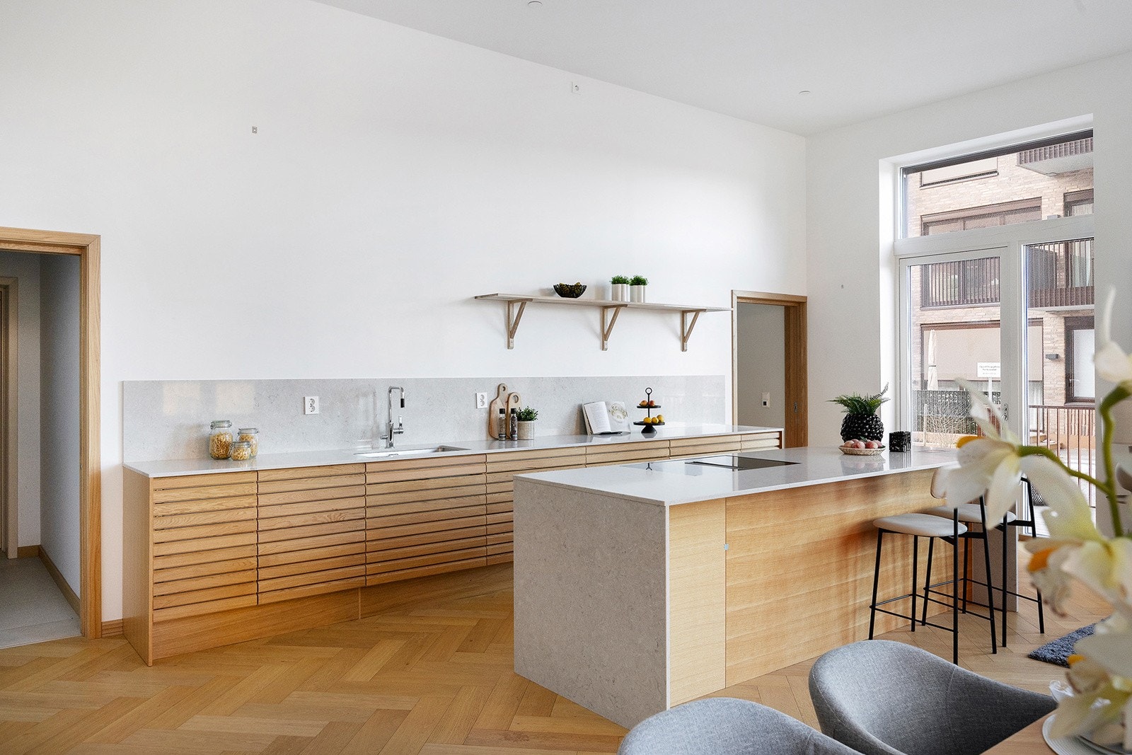 Kjøkkenet har et stilrent og tidløst uttrykk levert av HTH, med heltre profilerte fronter og benkeplate i stein. Galleribilde