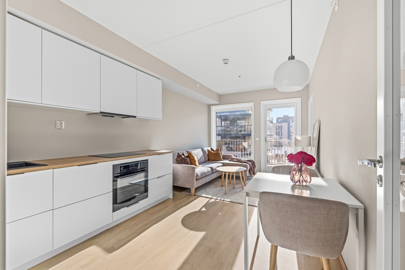 De hvite, slette frontene kombinert med laminert benkeplate gir et tidløst og lett uttrykk, mens benkebelysning og stikkontakter under overskap gir gode arbeidsforhold i hverdagen. Galleribilde