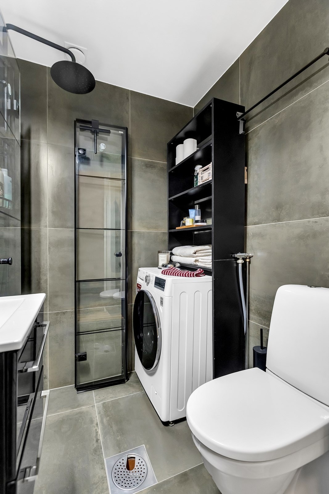 Badet er innredet med veggmontert WC, servant med ettgreps blandebatteri i innredning og praktisk oppbevaringsplass. Galleribilde