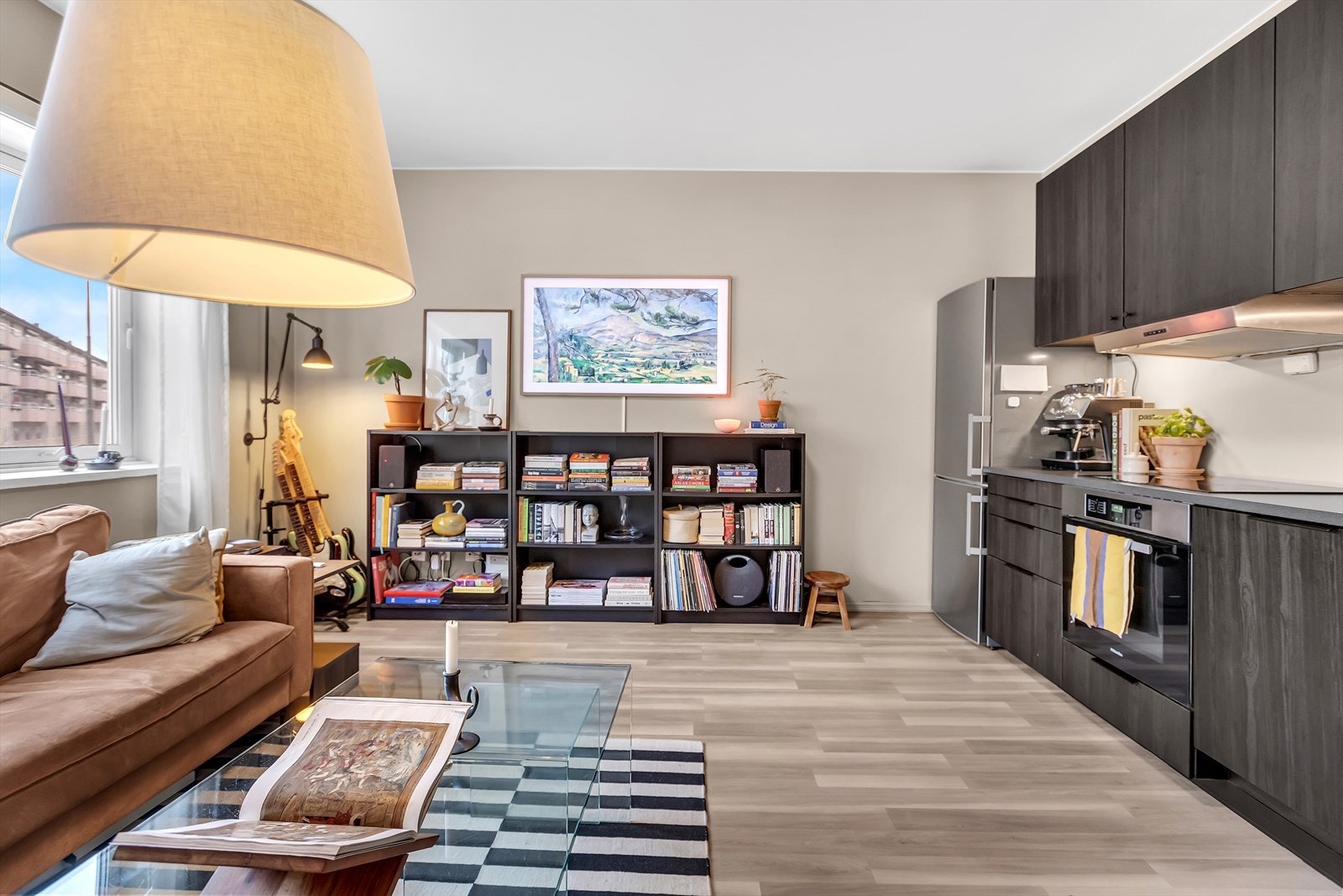 Leiligheten har en lys og romslig stue med åpen kjøkkenløsning som skaper en sosial og innbydende atmosfære. Galleribilde