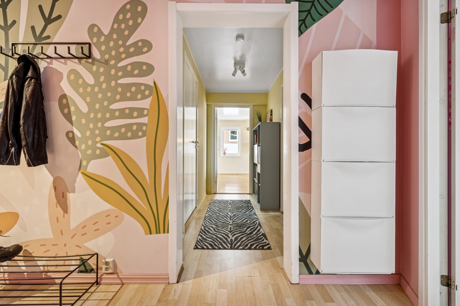 Lun og innbydende entré som ønsker deg velkommen inn i boligen. Her er det plass til å henge fra seg yttertøyet. Galleribilde