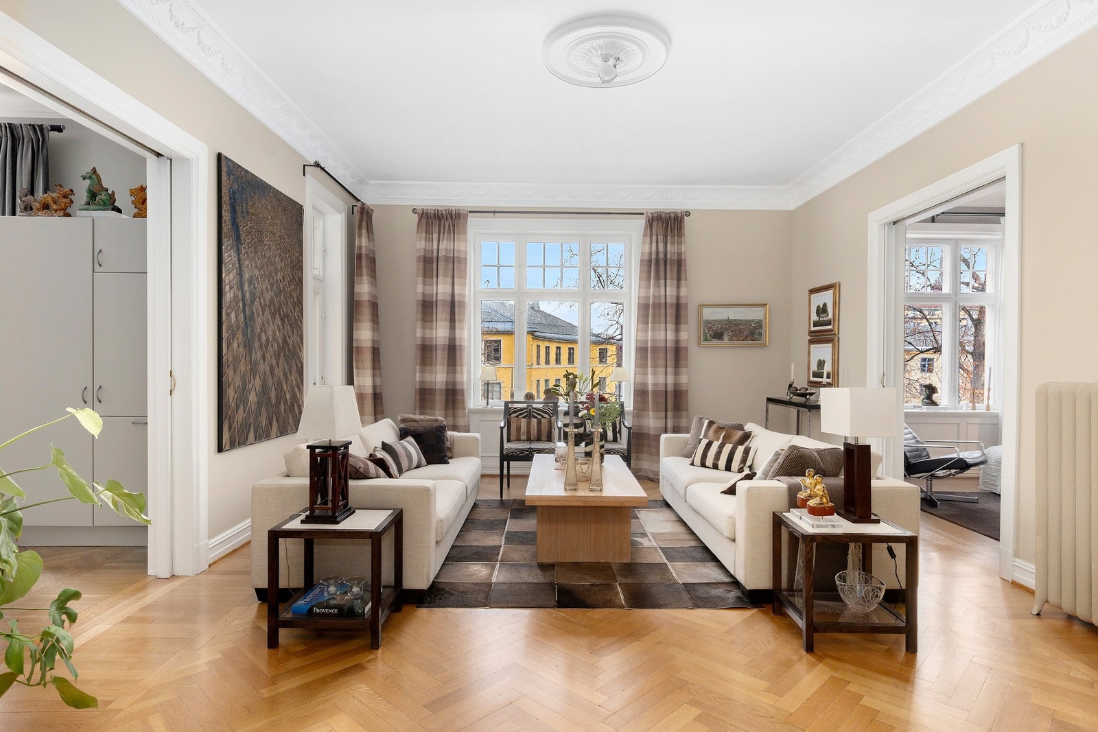 Romslig og lys stue med enstavs fiskebensparkett, store vindusflater som gir rikelig med lysinnslipp. Galleribilde