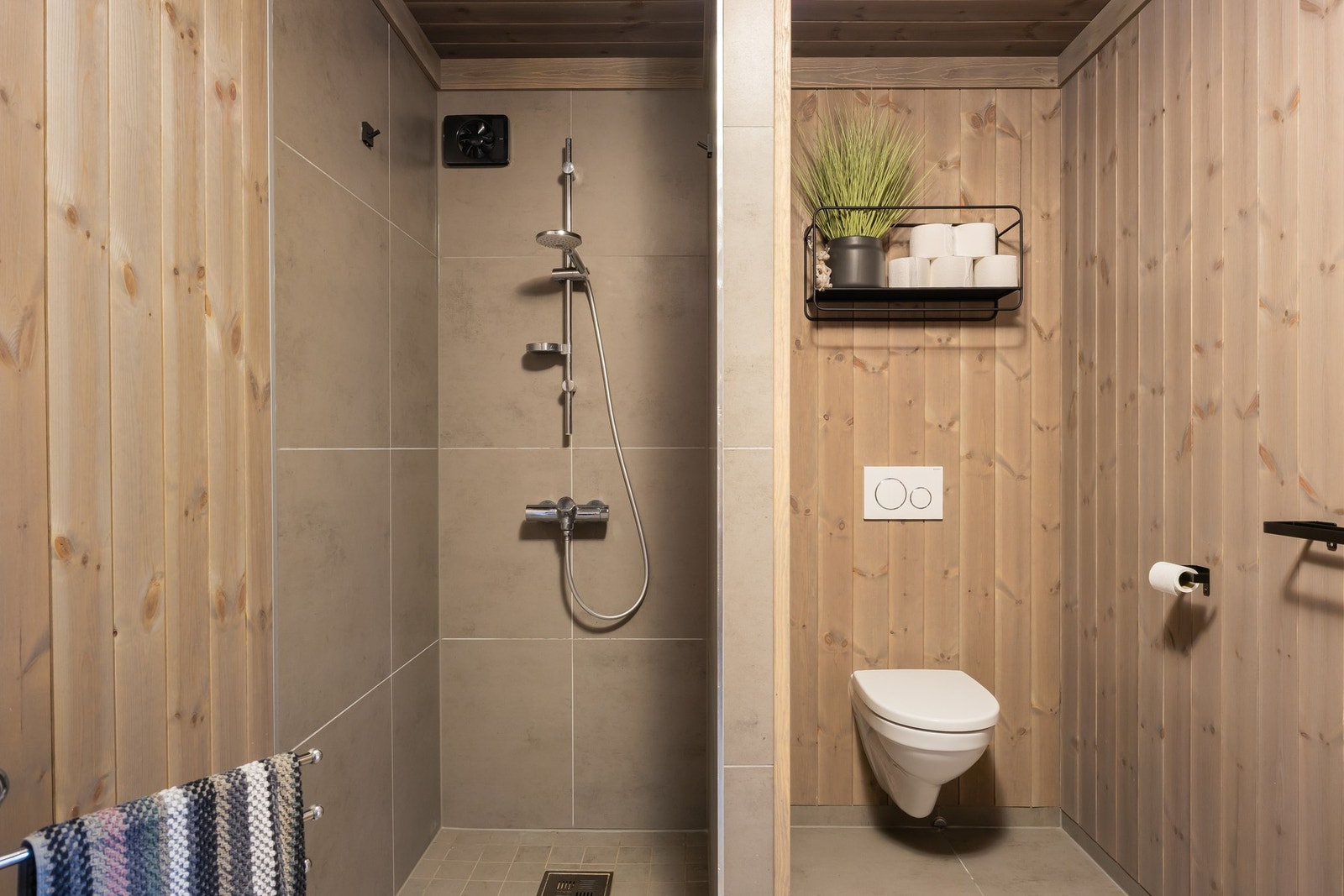 Bad 2 er utstyrt med åpen dusjsone, vegghengt toalett og innredning med servant. Galleribilde