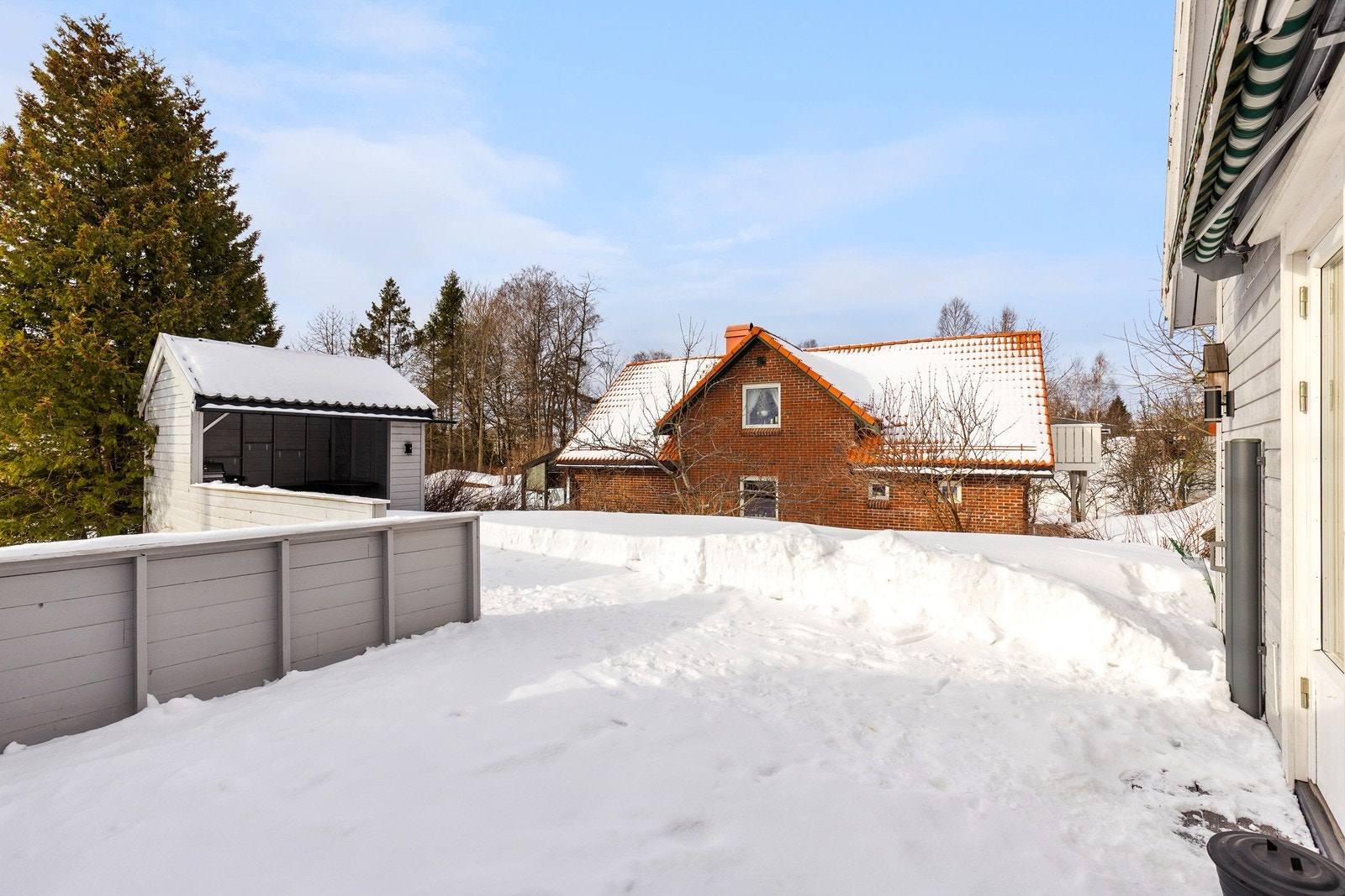 Romslig terrasse med hyggelig utestue - her kan man sitte under tak, nyte sene sommerkvelder eller tenne bålpanne på vinteren. Utestua kan møbleres etter ønske og gir en lun og deilig uteplass uansett vær. Galleribilde