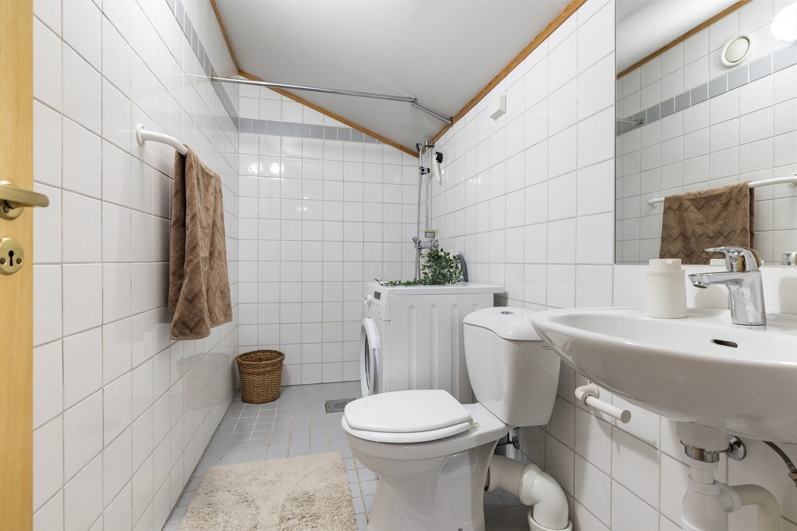 Badet inneholder dusj, servant, toalett og opplegg til vaskemaskin. Galleribilde