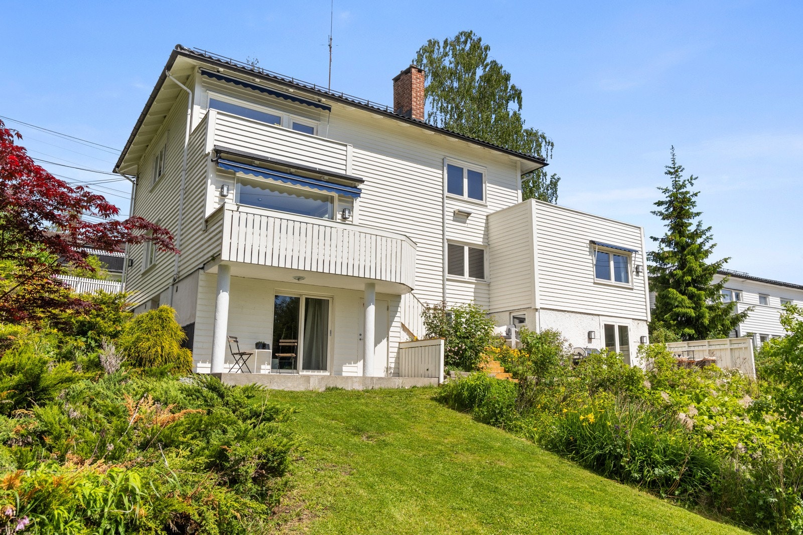 Hagen er skrånet med diverse busker, trær og plantevekster. Galleribilde