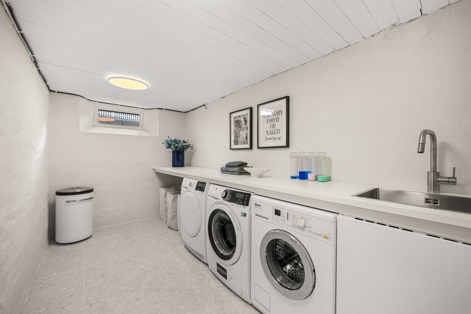 Stort vaskerom med varmekabler og opplegg for vaskemaskin og tørketrommel. Galleribilde