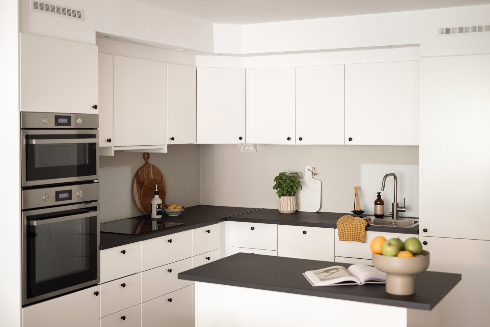 Lys og moderne kjøkkeninnredning fra Ikea som var ny i 2022. Innredningen har hvite glatte fronter og laminert benkeplate med nedfelt oppvaskkum. Galleribilde