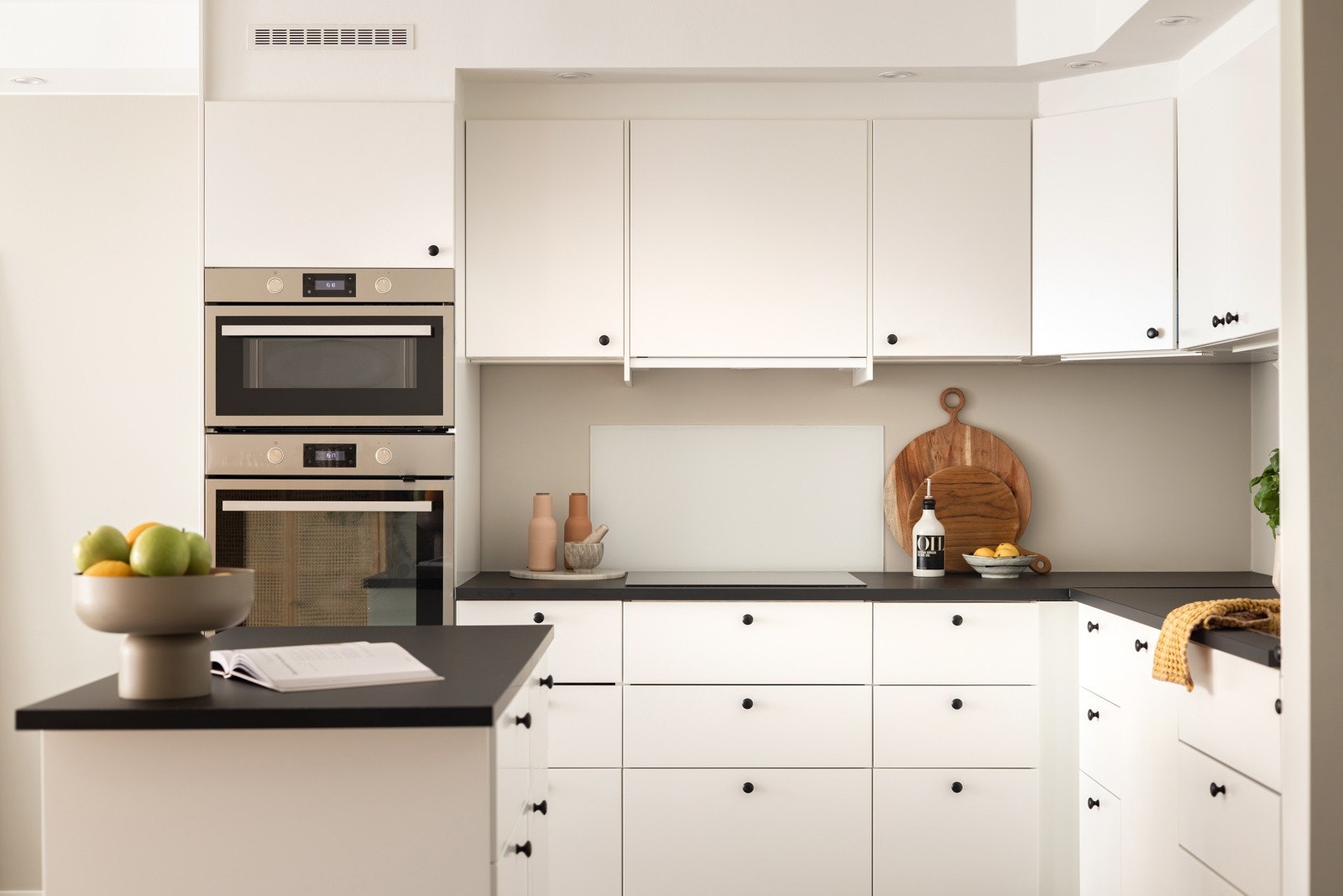 Praktisk med glassplater i benkeryggen ved platetoppen og oppvaskkummen, samt belysning under overskapene. Galleribilde