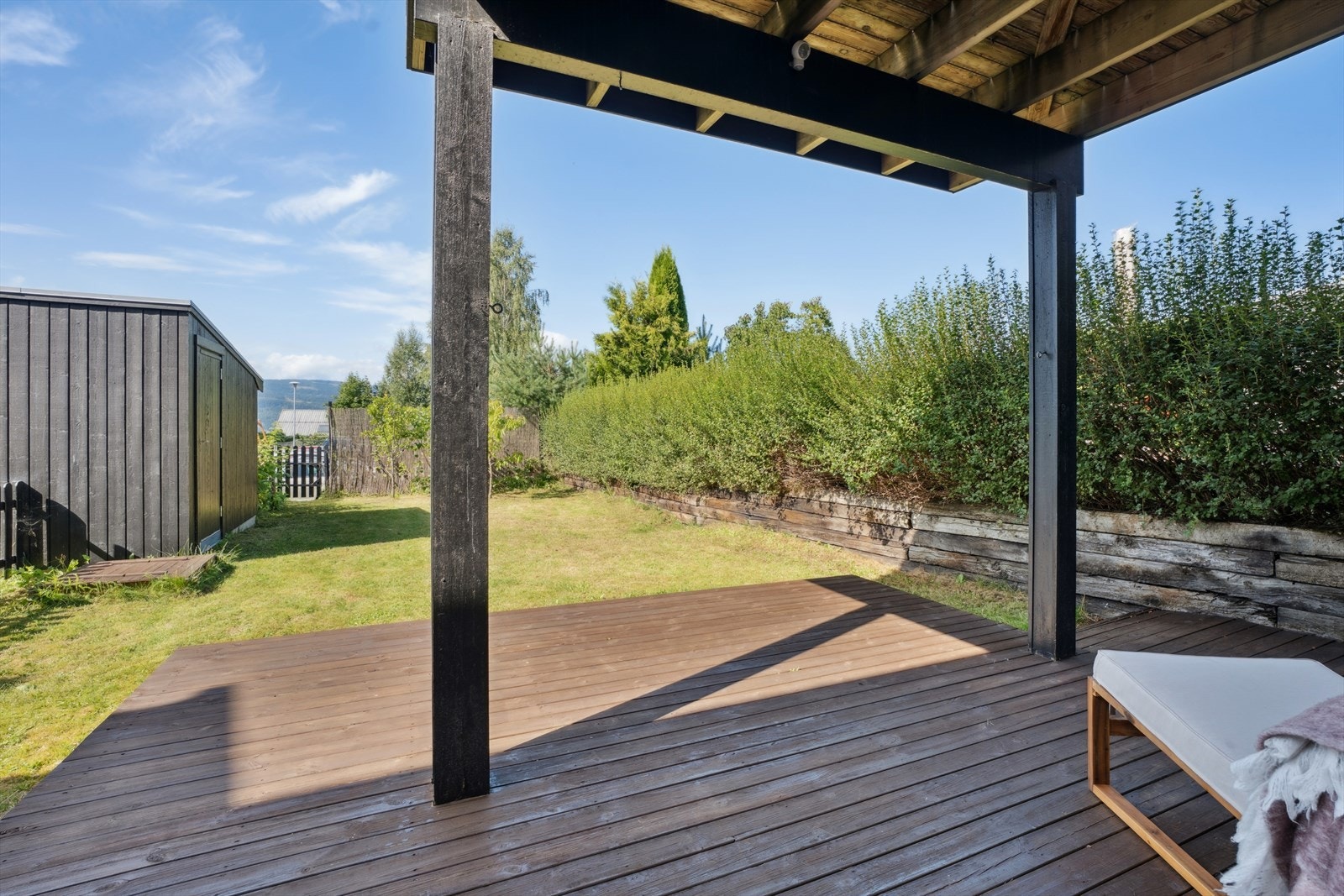 Tomten har en lettstelt liten hage med plenarealer, hekk, busker og beplantning. Galleribilde