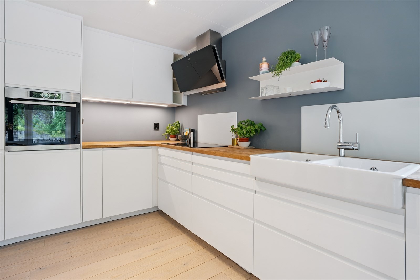 Kjøkkeninnredningen, levert av IKEA og installert i 2019, er pent utført med hvite, glatte fronter og heltre benkeplate med nedfelt keramisk oppvaskkum. Galleribilde