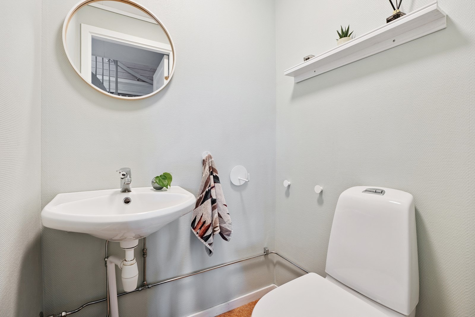 Toalettrommet i første etasje har belegg på gulvet og malt strie/plater på veggene. Galleribilde