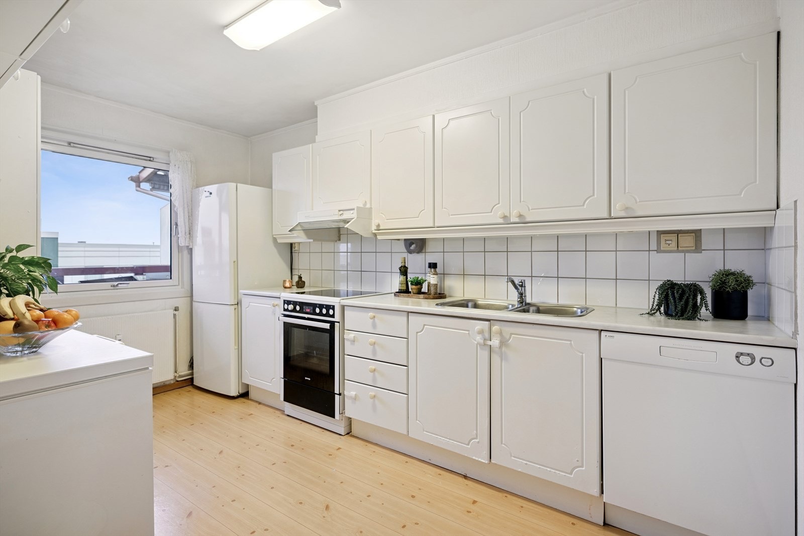 Praktisk kjøkken med Norema-innredning, god benkeplass og rom for en liten spiseplass. Galleribilde