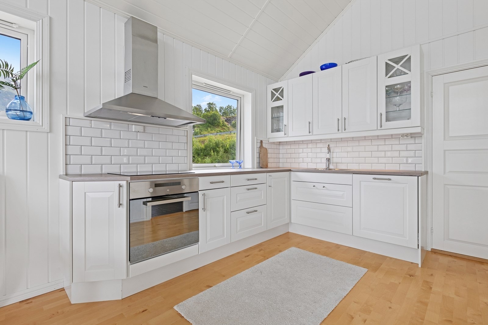 Moderne kjøkkeninnredning i god kvalitet med hvitevarer og finfin utsikt fra kjøkkenvinduet. Galleribilde