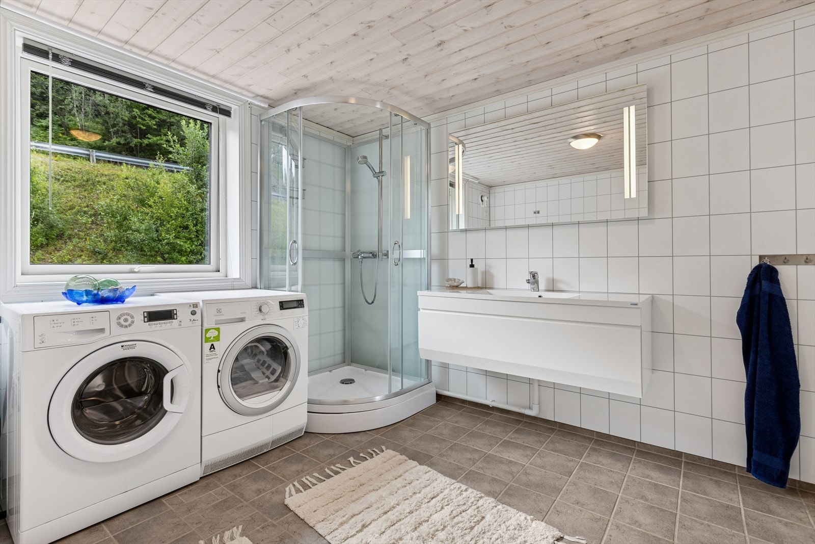 Baderommet er stort og godt utstyrt. Bred og fin innredning med skuffeseksjon, stort speil med belysning, dusjkabinett og komplett rigg for vask/tørk. Galleribilde