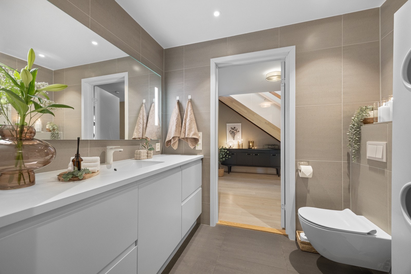 Badet er innredet med dusjhjørne, opplegg for vaskemaskin og vegghengt toalett, med innredning fra HTH. Galleribilde