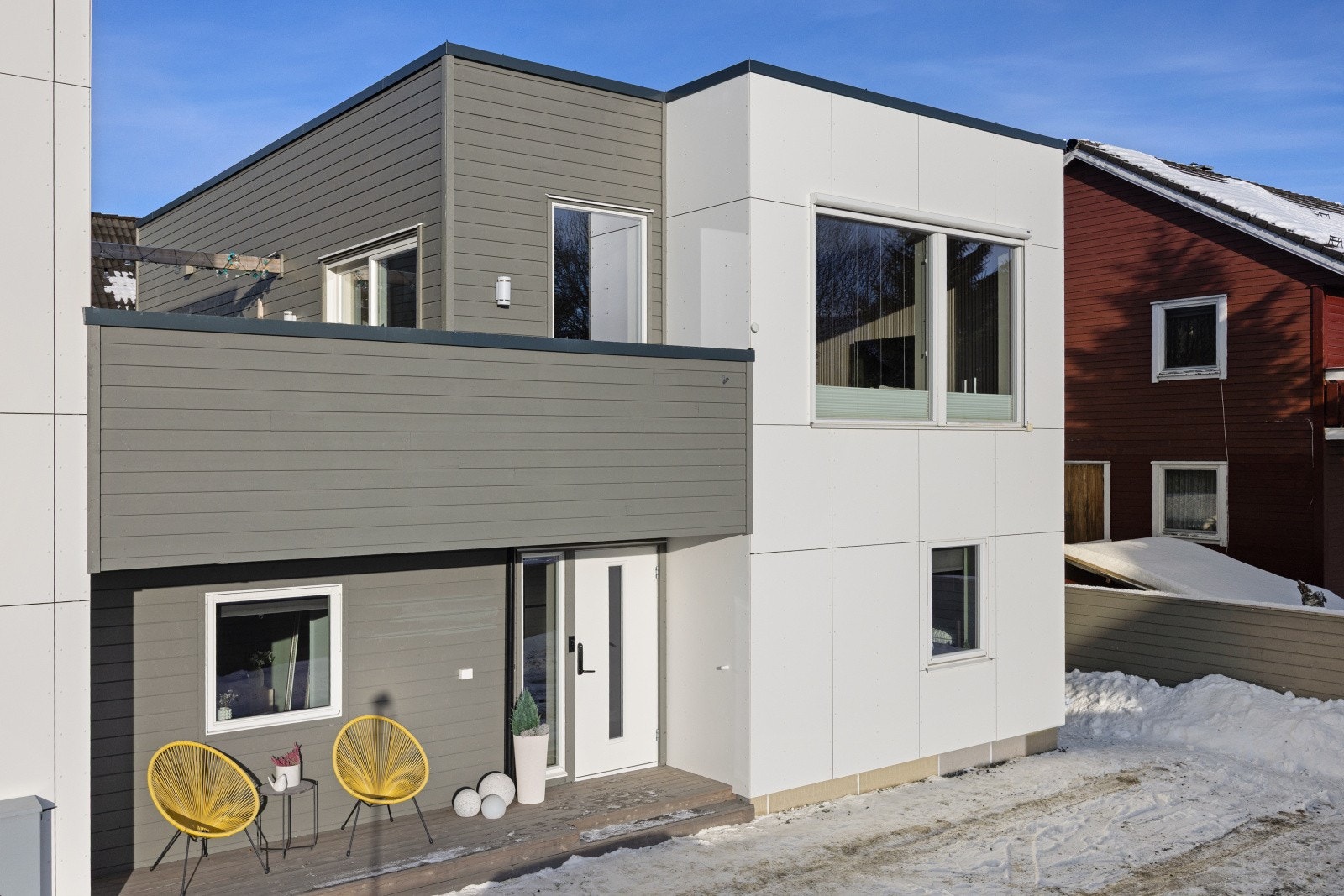 På gårdsplassen er det godt med plass til parkering. Her er det også lagt opp elbil lader på husveggen. Galleribilde