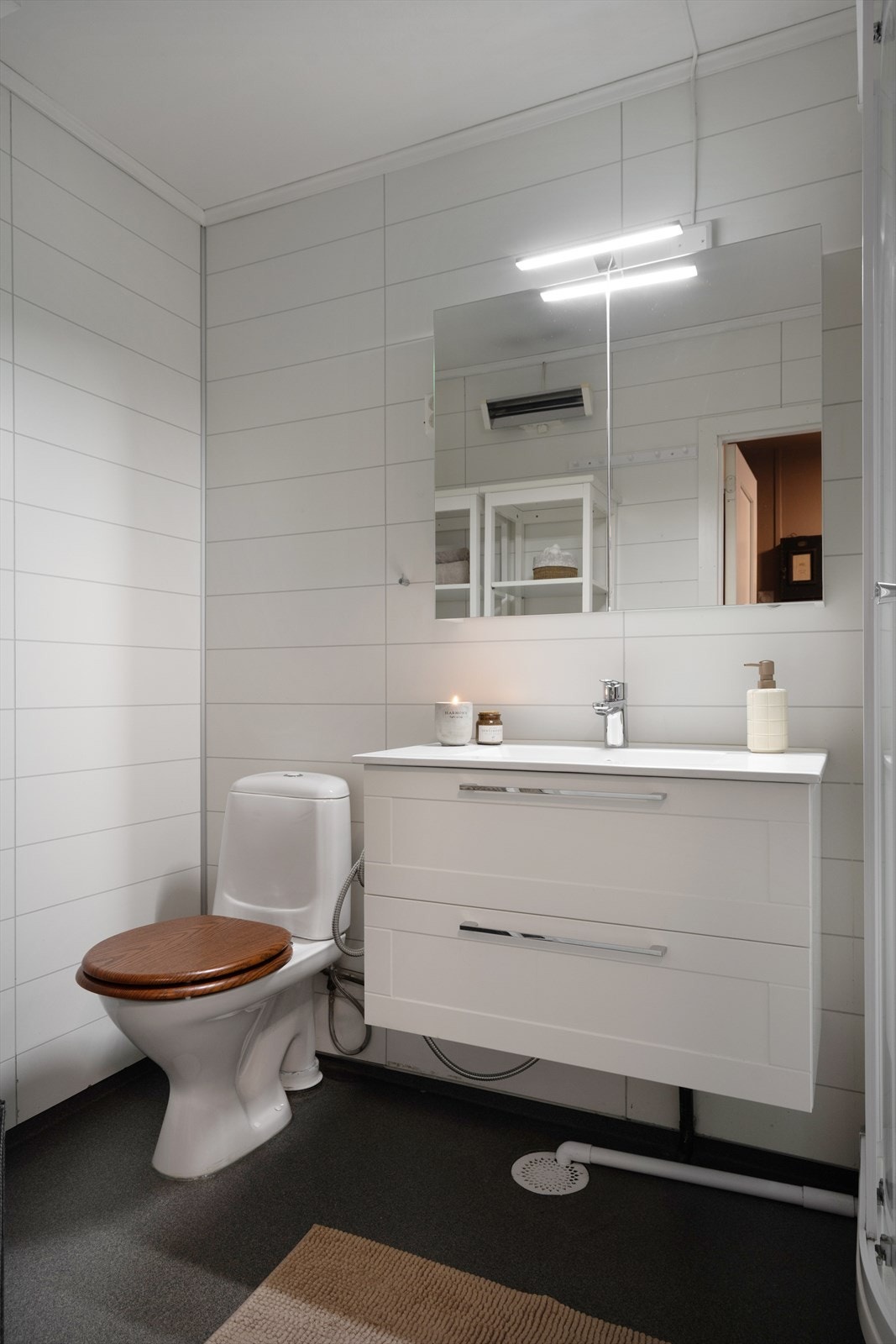 Pent bad innredet med dusjkabinett, servant med innredning, speilskap og toalett. Galleribilde