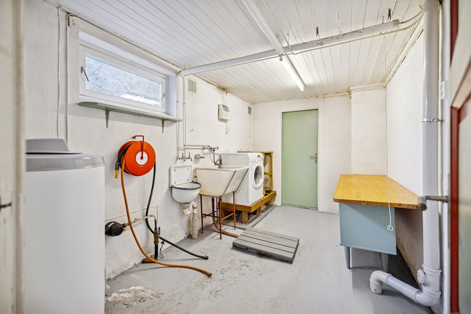 Stort og praktisk vaskerom i kjelleren med utslagskum og opplegg for vaskemaskin. Galleribilde