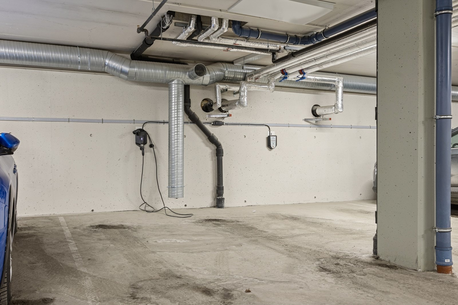 Parkeringsplass i kjeller med elbillader. Galleribilde