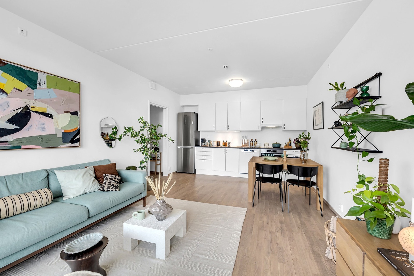 Boligen har en moderne og åpen stue- og kjøkkenløsning som skaper en luftig og sosial atmosfære. Galleribilde