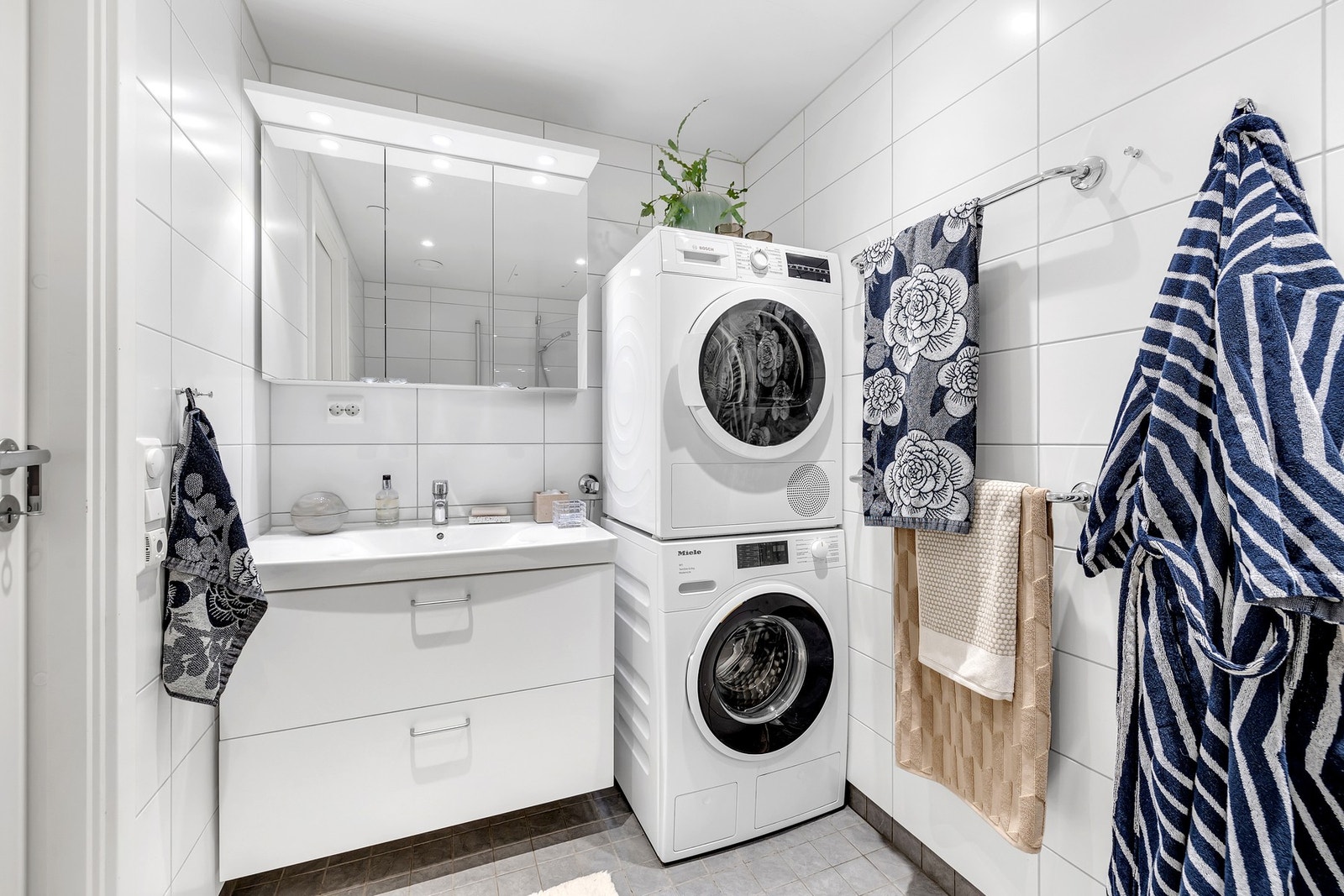 Badet har vegghengt toalett med innebygd sisterne kasse, servant på vegghengt
servantskap. Galleribilde