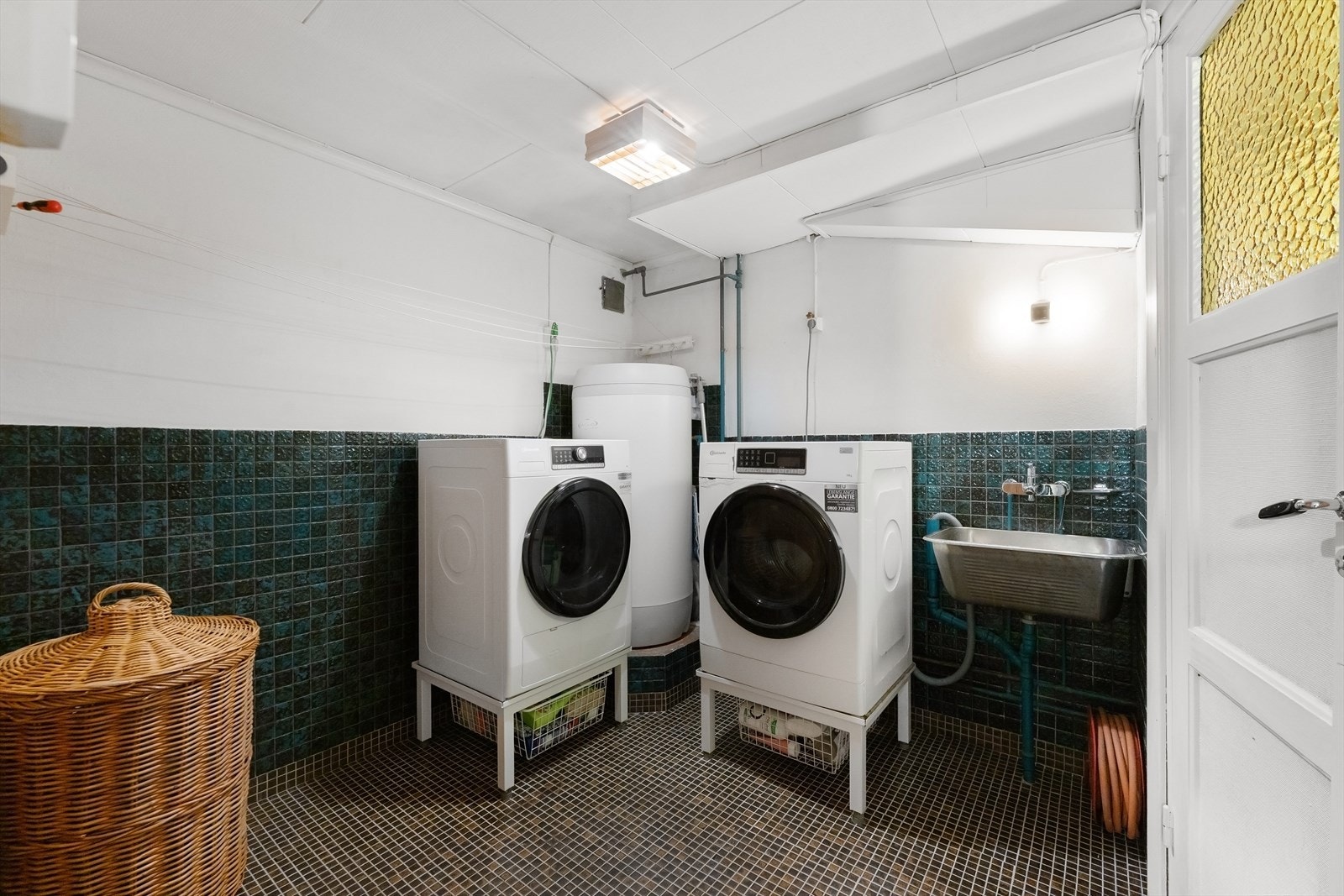 Praktisk og separat vaskerom i kjelleren med opplegg for vaskemaskin og tørketrommel samt utslagsvask. Galleribilde