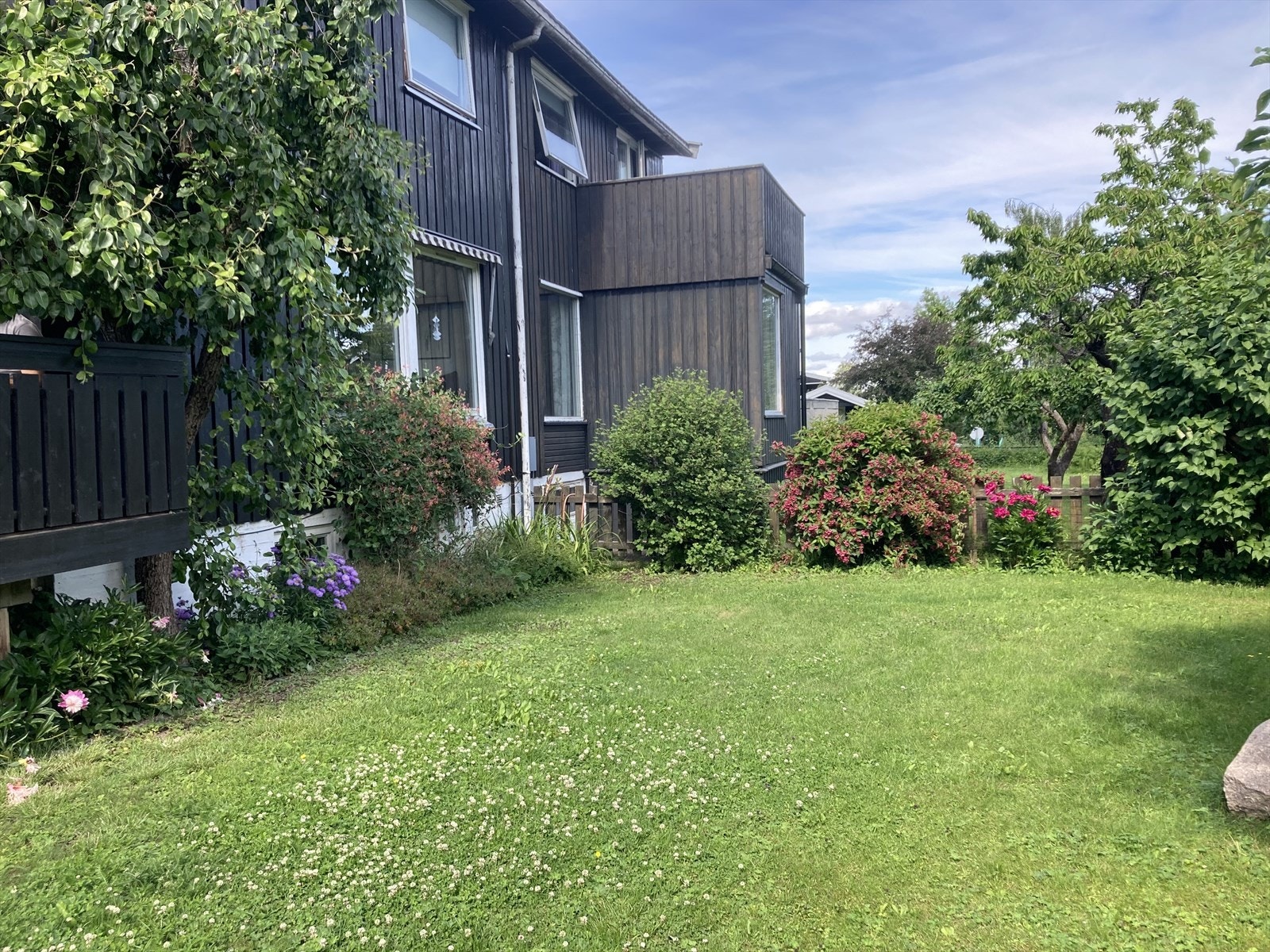 Tomten er flott opparbeidet med gressplen, bærbusker, frukttrær, busker og blomsterbusker. (Selgers bilde) Galleribilde