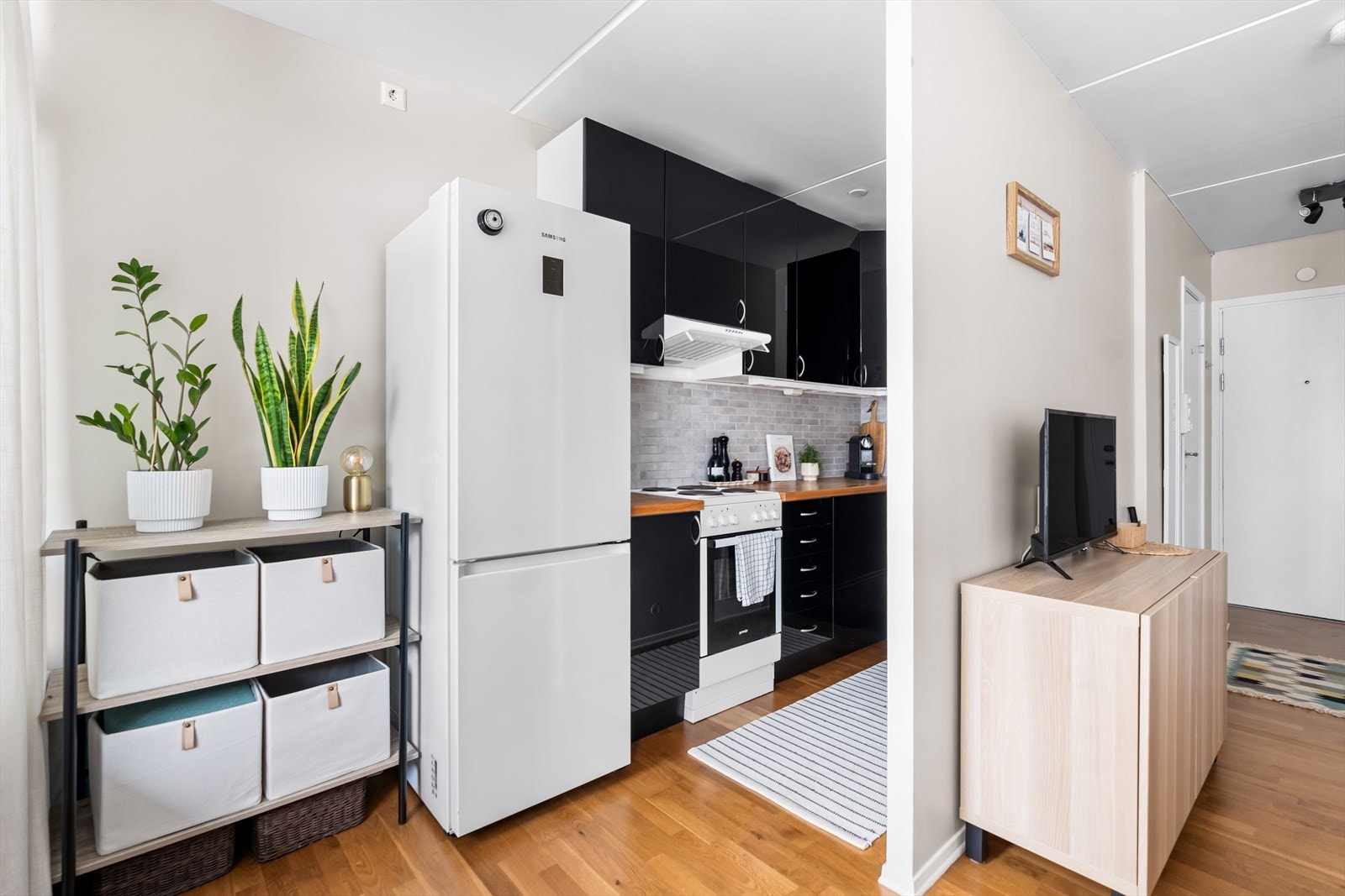 Kjøkkeninnredningen har sorte fronter, samt en heltre benkeplate med nedfelt oppvaskkum og 1-greps blandebatteri. Galleribilde