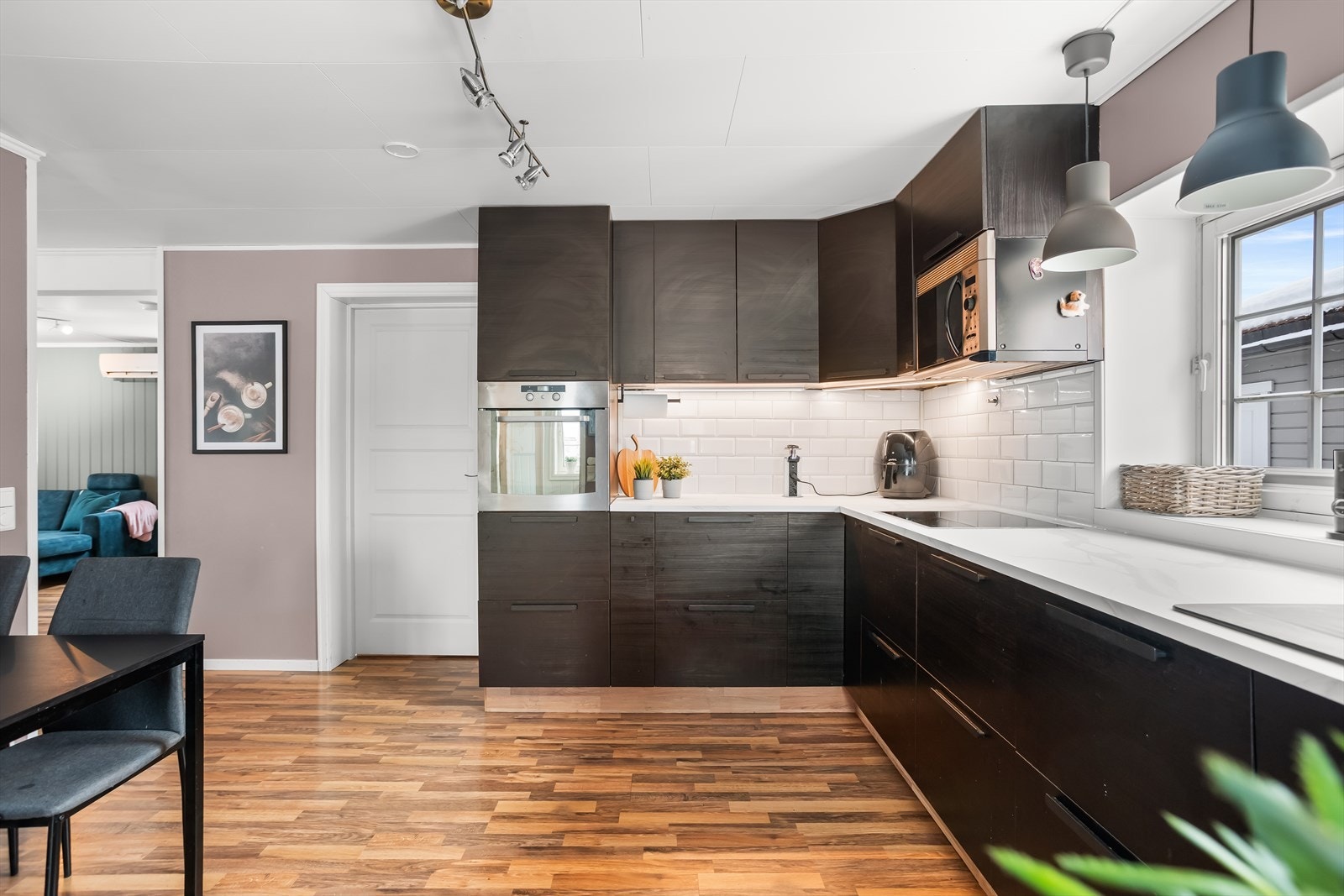 Kjøkkenet har et stilrent og moderne preg med mørke glatte fronter og benkeplate i laminat. Galleribilde