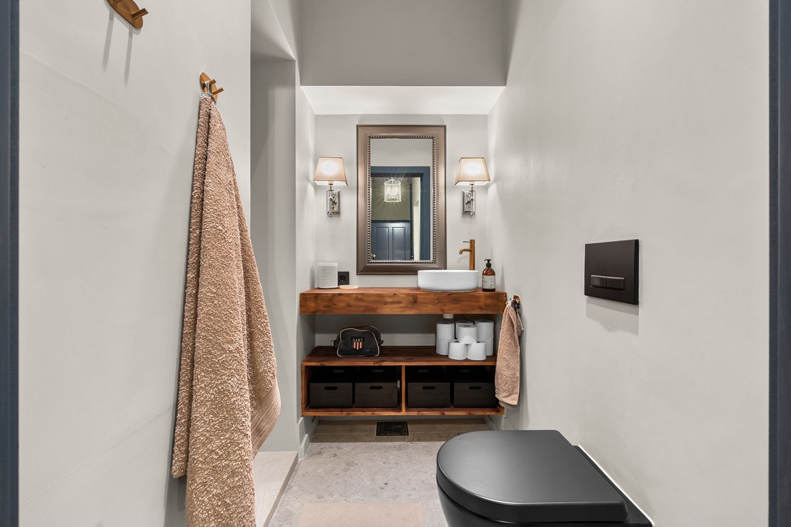 Badet fremstår moderne og delikat med et stilrent uttrykk og gjennomførte materialvalg. En lekker servant plassert på en solid benkeplate i tre tilfører varme til rommet og skaper en fin kontrast til de lyse overflatene. Galleribilde