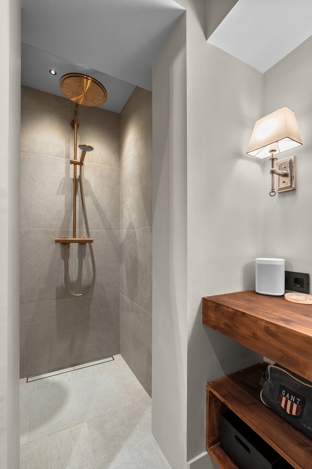 Dusjsonen er stilrent utført med store fliser og rene linjer som gir et moderne preg. Takmontert regndusj sørger for en behagelig opplevelse, og den åpne løsningen gir en luftig romfølelse. Galleribilde