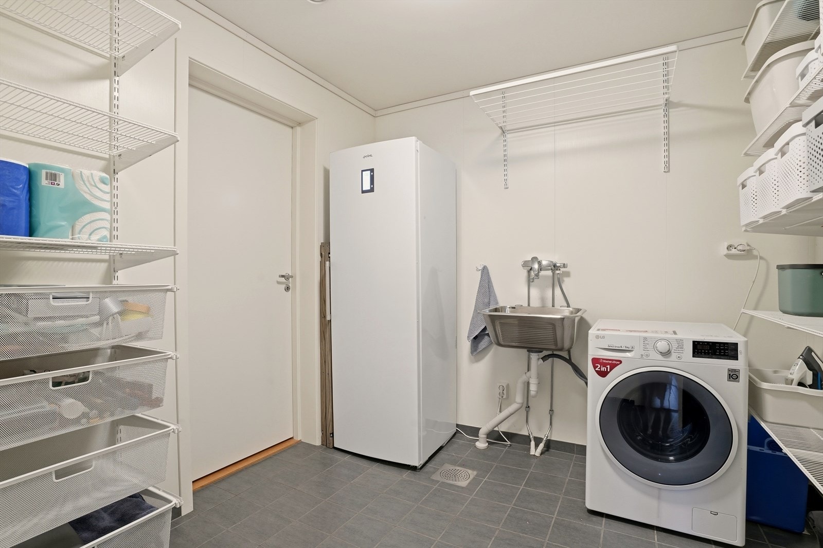 Et praktisk vaskerom med god oppbevaringsplass og opplegg for vaskemaskin. Galleribilde