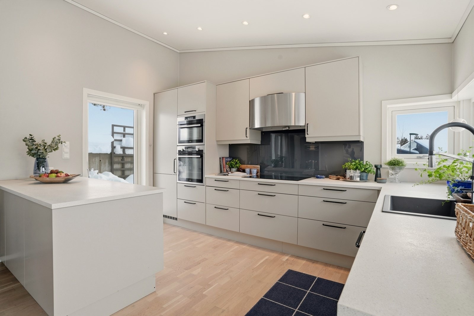 Kjøkkenet har glatte fronter, svarte håndtak og laminat benkeplate. Galleribilde