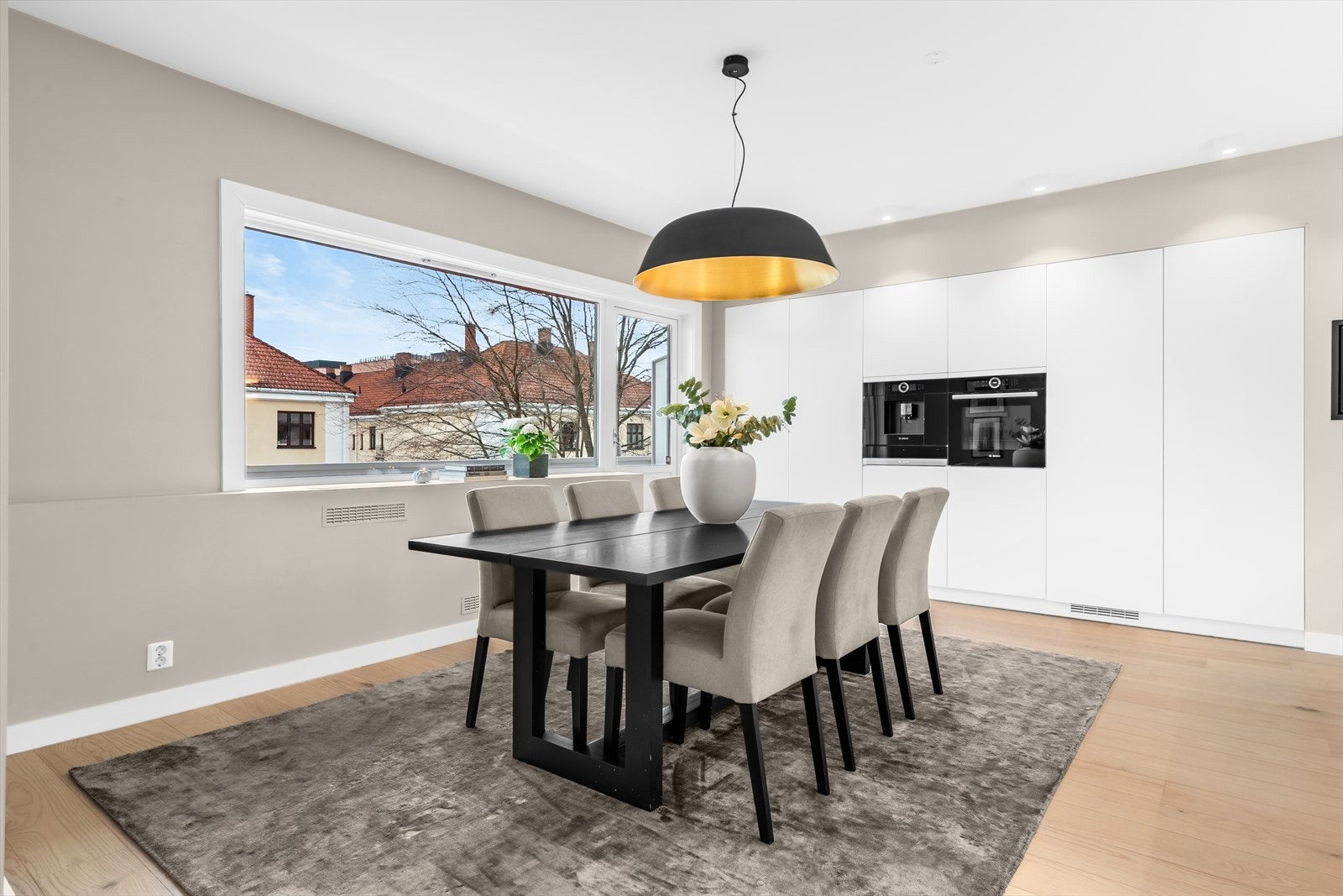 Store vindusflater og utgang til balkongen fra kjøkken/spisestue. Svært god plass til spisebord/langbord. Galleribilde