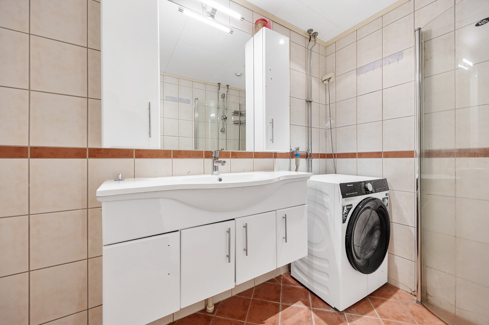 Her er det opplegg for vaskemaskin, innredning med servant og dusj på gulv. Galleribilde