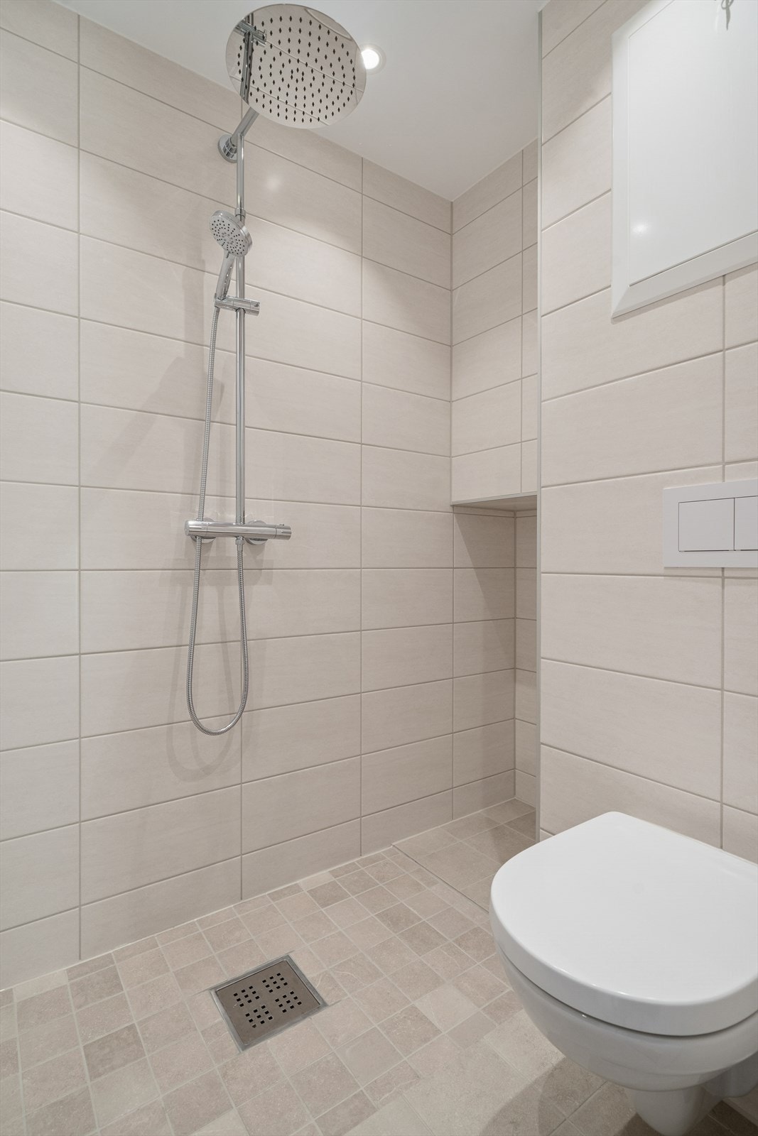 Badeværelset er lekkert og utført med dusj, vegghengt toalett, servant og opplegg for vaskemaskin Galleribilde