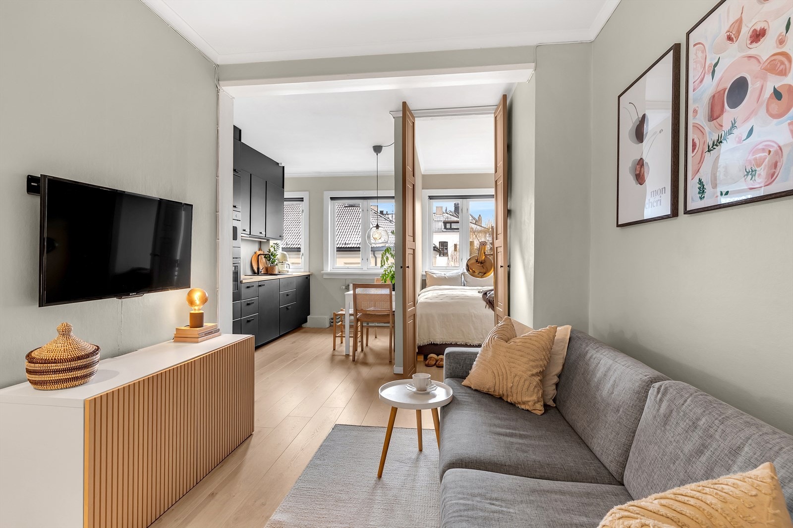 Laminatgulv og malte veggflater gir en lys og moderne stue. Galleribilde